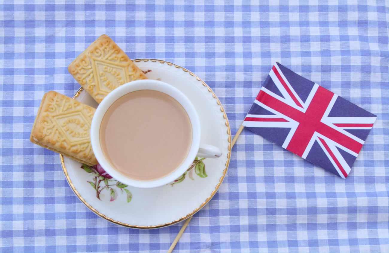 A tea cup with biscuits and the flag of the United Kingdom