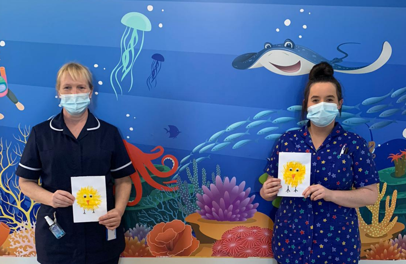 Two paediatric nurses hold Easter cards