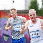 A man in a WISHH vest running the Run for All