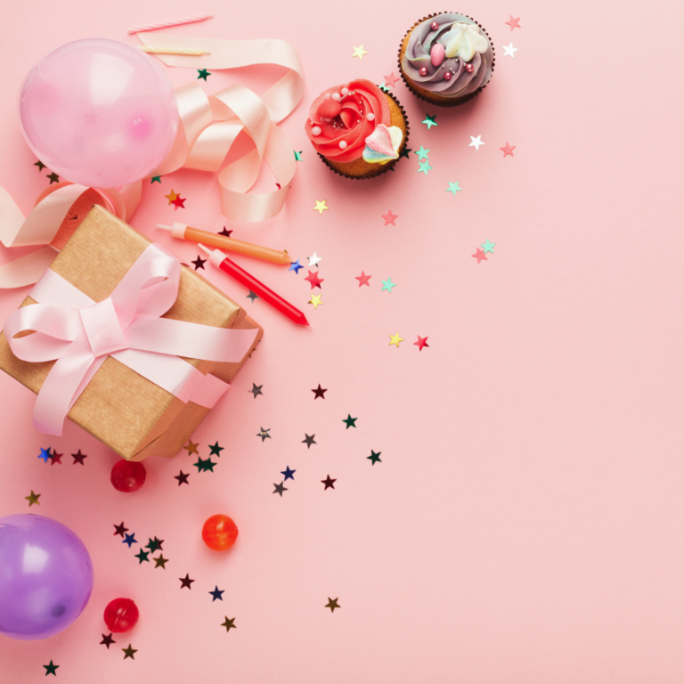 A pink background with a present, confetti, balloons and cupcakes