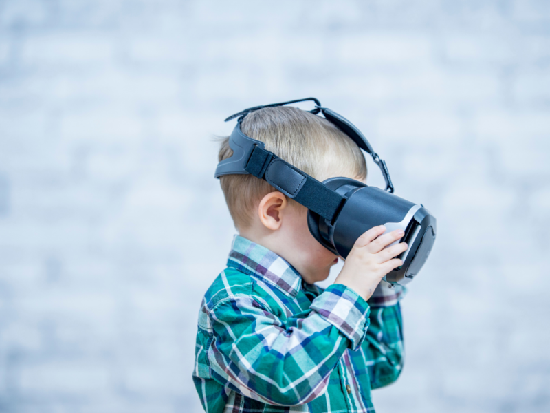 A little boy uses a virtual reality headset
