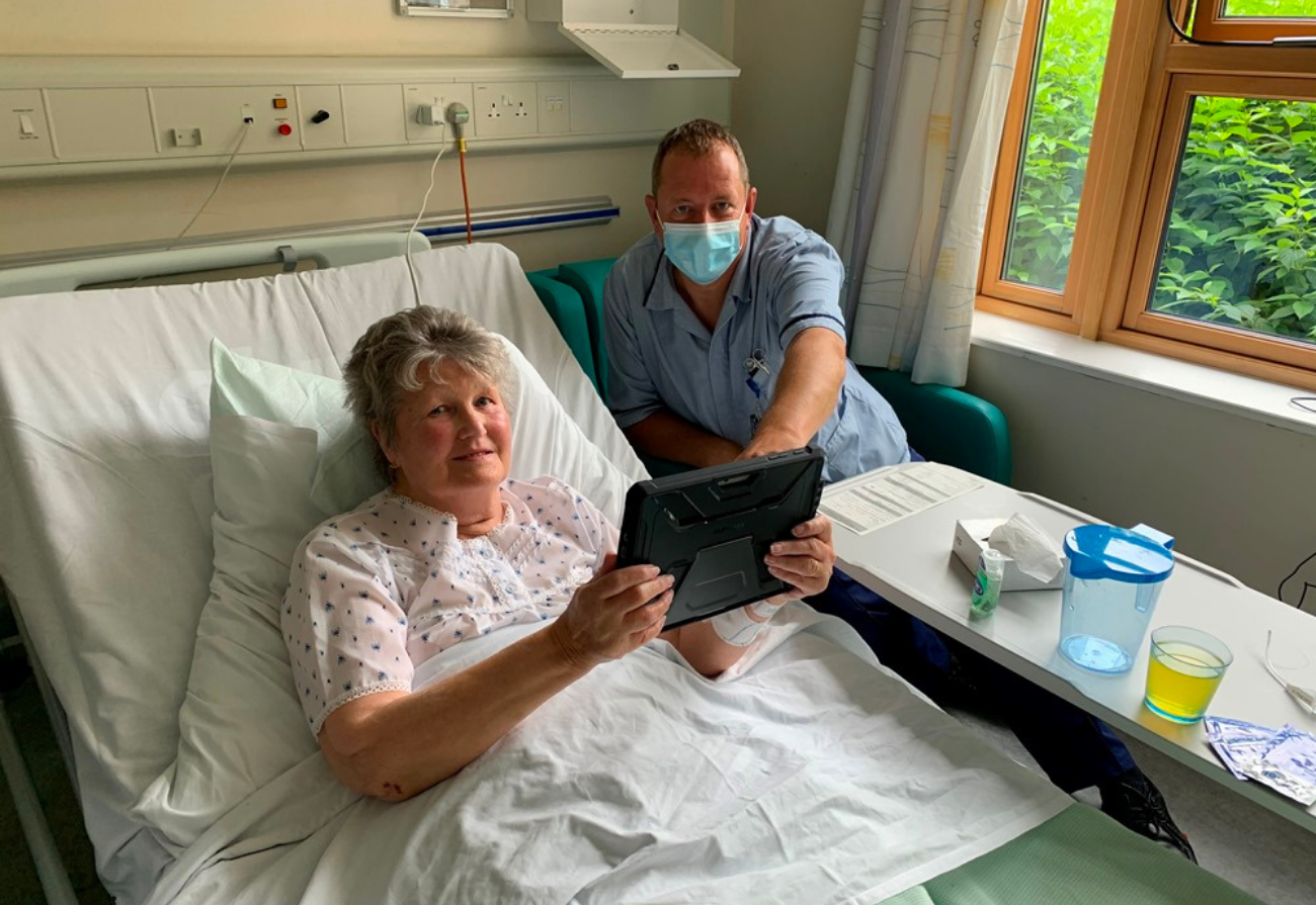 A nurse and a patient look at a tablet