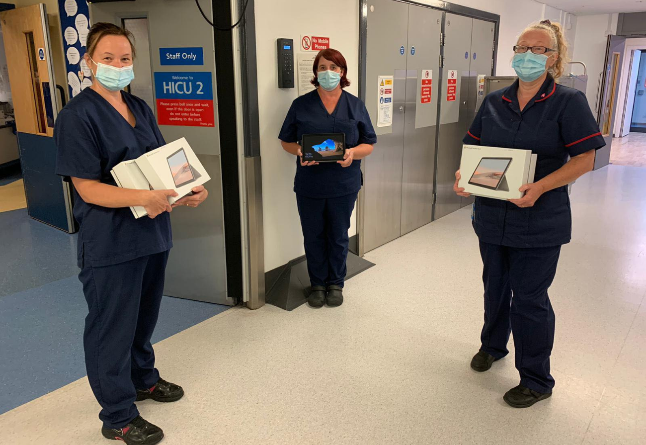Three nurses hold tablet donations