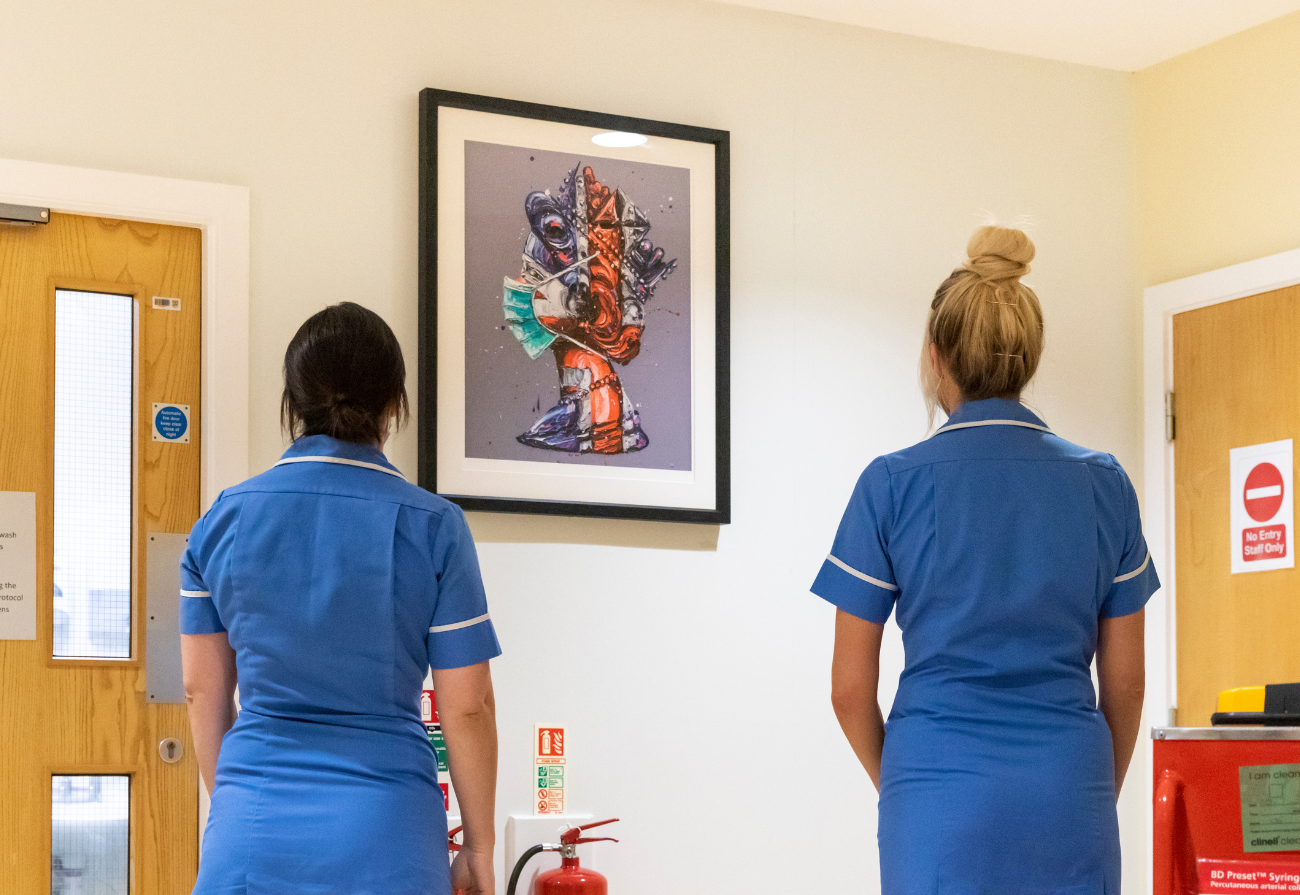 Two nurses look at the Corona Queen artwork