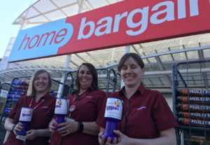 Home Bargains staff members hold WISHH Charity tubs