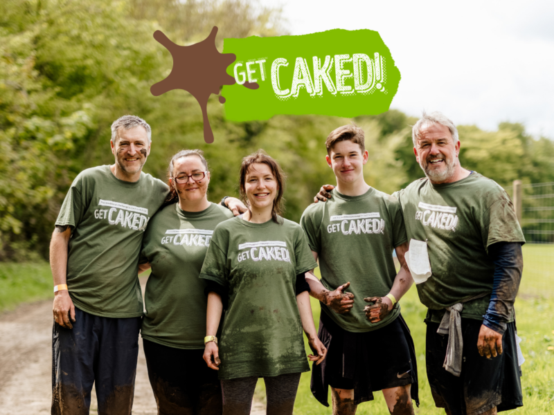 Five people are stood looking happy and muddy. They have taken part in Get Caked event.